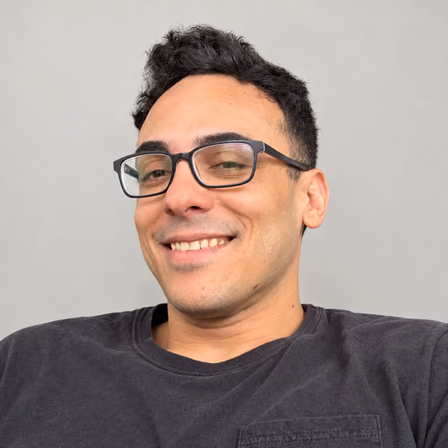 Antonio Rodríguez Martínez, smiling, in glasses and a dark T-shirt, against a gray wall